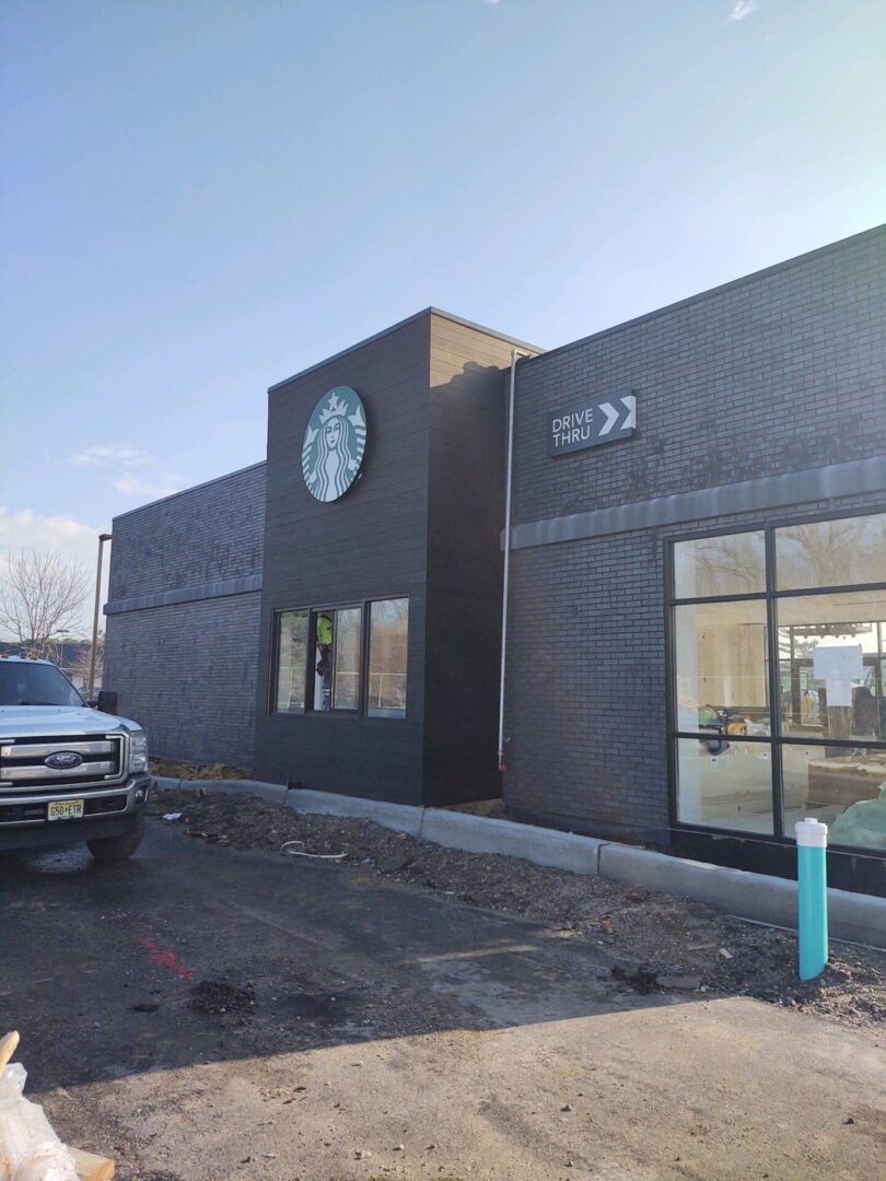 A Starbucks Building With a Car Parked Outside